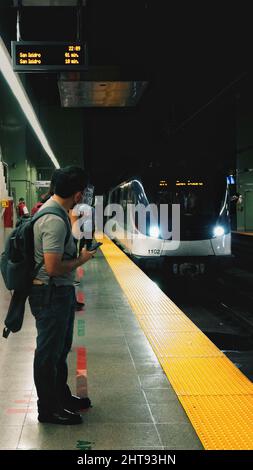 Vertikale Aufnahme eines Mannes, der in der Metro in Panama auf die U-Bahn wartet. Stockfoto