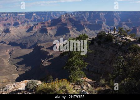 Zwei weibliche Wanderer genießen den Blick auf Klippen, Felswände und Felsschichten in den Tiefen des Grand Canyon am Shoshone Point am Südrand Stockfoto