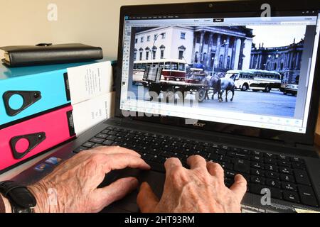 Alte Hände an einer Computertastatur, die Bilder finden, um angenehme Erinnerungen auszulösen, wenn man älter wird. Der Transport in Ost-Berlin war interessant und alt Stockfoto