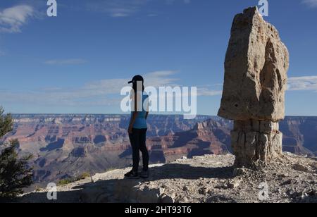 Ein Mädchen blickt auf die Klippen, Felswände und Felsschichten hinunter in die Tiefen des Grand Canyons am Shoshone Point am Südrand. Shoshone Point Stockfoto