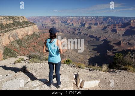 Ein Mädchen blickt auf die Klippen, Felswände und Felsschichten hinunter in die Tiefen des Grand Canyons am Shoshone Point am Südrand. Shoshone Point Stockfoto