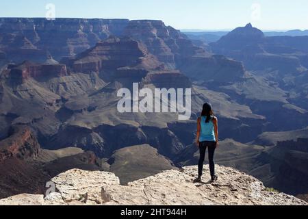 Ein Mädchen blickt auf die Klippen, Felswände und Felsschichten hinunter in die Tiefen des Grand Canyons am Shoshone Point am Südrand. Shoshone Point Stockfoto