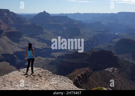 Ein Mädchen blickt auf die Klippen, Felswände und Felsschichten hinunter in die Tiefen des Grand Canyons am Shoshone Point am Südrand. Shoshone Point Stockfoto