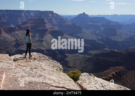 Ein Mädchen blickt auf die Klippen, Felswände und Felsschichten hinunter in die Tiefen des Grand Canyons am Shoshone Point am Südrand. Shoshone Point Stockfoto