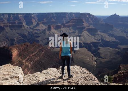 Ein Mädchen blickt auf die Klippen, Felswände und Felsschichten hinunter in die Tiefen des Grand Canyons am Shoshone Point am Südrand. Shoshone Point Stockfoto