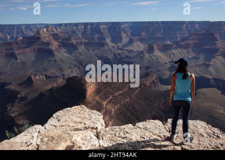 Ein Mädchen blickt auf die Klippen, Felswände und Felsschichten hinunter in die Tiefen des Grand Canyons am Shoshone Point am Südrand. Shoshone Point Stockfoto