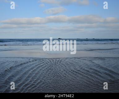 Sandstrand bei Ebbe, das Wasser bildet kleine Wellen am Ufer, Caleta de Famara, Lanzarote, Kanarische Inseln Stockfoto