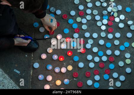 London, Großbritannien, 27.. Feb 2022 Ein Mann zündet Kerzen an, um an die Menschen zu erinnern, die bei den jüngsten Angriffen Russlands auf die Ukraine bereits ihr Leben verloren haben. Quelle: Kiki Streitberger/Alamy Live News Stockfoto