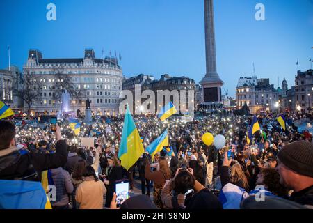 London, Großbritannien. 27.. Februar 2022. Pro-ukrainische Demonstranten halten Fahnen und leuchten auf, während sie auf dem Trafalgar-Platz gegen die russische Invasion in der Ukraine protestieren. (Foto von Lucy North/SOPA Images/Sipa USA) Quelle: SIPA USA/Alamy Live News Stockfoto