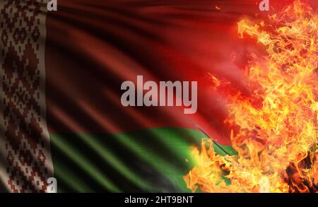 3D Komposit-Illustration, die die Nationalflagge der Republik Belarus darstellt, die von der sowjetunion geerbt wurde und von den Flammen bedroht und verbrannt wurde Stockfoto