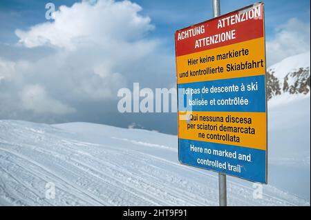 Nahaufnahme eines Warnschildes auf einem verschneiten Matterhorn-Bergweg in der Schweiz Stockfoto