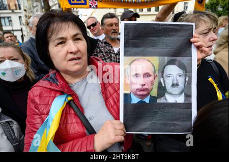 Sevilla, Spanien. 27.. Februar 2022. Eine ujrainische Frau hält ein Banner, das den russischen Präsidenten Wladimir Putin mit Adolf Hitler vergleicht. Während der Demonstration nannten verschiedene Personen Putin als „Mord“. Ukrainische Bürger, die in Sevilla lebten, machten eine Demonstration, um ihr Land und ihre Regierung zu unterstützen und gegen die russische Invasion und Wladimir Putin. (Foto: Ángel García/Pacific Press) Quelle: Pacific Press Media Production Corp./Alamy Live News Stockfoto