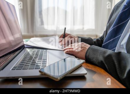 Nahaufnahme eines Geschäftsmanns, der im Büro einen Vertrag unterzeichnet. Stockfoto