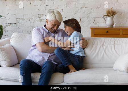 Älterer Großvater mit Spaß spielen mit kleinen niedlichen Enkel Stockfoto