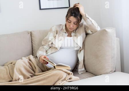 Kaukasische Schwangerin aus Bosnien und Herzegowina liest ein Buch Stockfoto