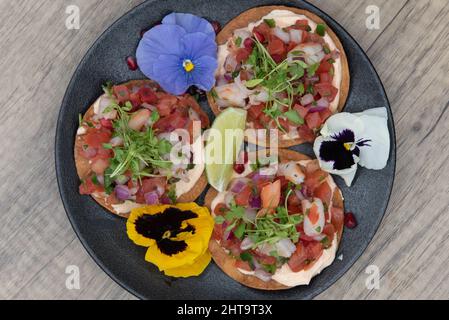 Blick von oben auf den geladenen Teller mit Ceviche Tacos, der mit all den frischen Meeresfrüchten gefüllt war. Stockfoto