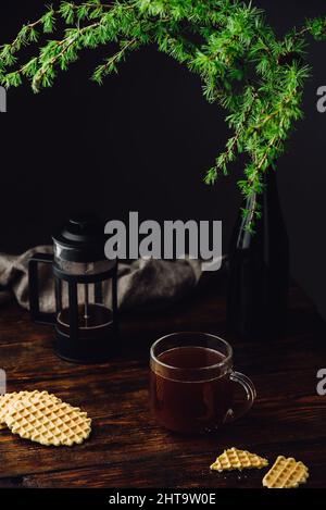 Tasse Kaffee in französischer Presse mit Waffeln gebrüht Rustikaler Holztisch Stockfoto