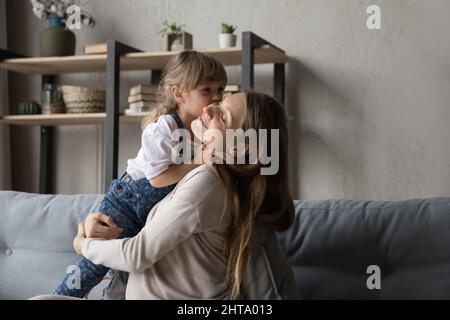 Friedliche positive junge, schwanger Mutter umarmt süße Vorschultochter Stockfoto