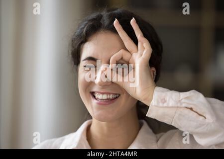 Nahaufnahme glückliche junge hispanische Frau, die binokulares Zeichen macht. Stockfoto