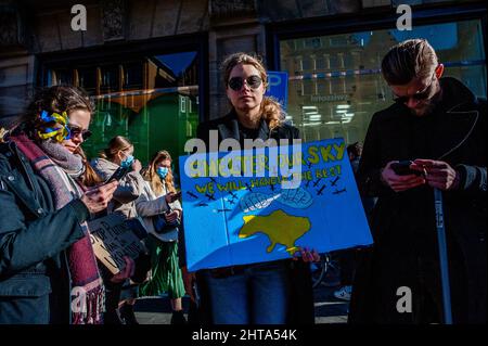 Eine Frau hält während der massiven Demonstration gegen Putins Invasion der Ukraine, die am 27.. Februar 2022 in Amsterdam organisiert wurde, ein Plakat mit der Bitte um Befreiung des ukrainischen Luftraums. Nach Putins Entscheidung, die Ukraine anzugreifen, wurden am selben Tag mehrere Proteste im Zentrum der Stadt organisiert, um ihre Unterstützung für das ukrainische Volk zu zeigen. Die ukrainische Gemeinschaft, die russische Gemeinschaft und mehrere Nichtregierungsorganisationen in den Niederlanden, begleitet von Tausenden von Menschen, versammelten sich auf dem Dam-Platz, um gegen Putin und den Krieg in der Ukraine zu protestieren (Foto von Romy Stockfoto