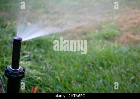 Nahaufnahme des strömenden Wassers aus einem automatischen Bewässerungssystem. Stockfoto