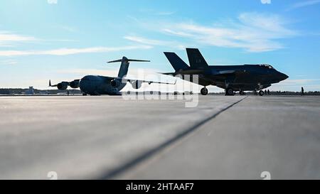 Eine C-17 Globemaster III der US-Luftwaffe vom Luftwaffenstützpunkt Hickam und eine F-35 Lightning II der Royal Air Force Lakenheath sind auf dem Flugplatz auf dem Luftwaffenstützpunkt Ämari, Estland, am 27. Februar 2022, geparkt. Mitglieder der FW 48., des 52. Fighter Wings vom Luftwaffenstützpunkt Spangdahlem, des 388. Fighter Wings vom Luftwaffenstützpunkt Hill und des 435. Air Ground Operations Wings vom Luftwaffenstützpunkt Ramstein wurden auf der Ämari ab eingesetzt, um die kollektive Verteidigung der NATO und die verstärkte Luftpolizierungsmission zu unterstützen. Verstärkte Luftkontrollmissionen stärken die Solidarität, den kollektiven Willen und die Fähigkeit der Allianz, sich an einen dynamischen Krieg anzupassen, kontinuierlich Stockfoto