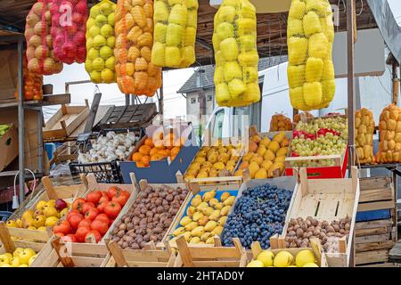 Frisches, rohes Bio-Obst und Gemüse in Karton und Holzkisten draußen am Marktstand Stockfoto