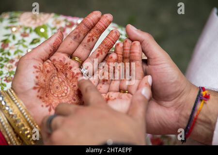 Nahaufnahme einer Braut und eines Bräutigams mit Ringen bei einer traditionellen indischen Hochzeit Stockfoto