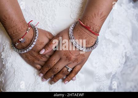 Nahaufnahme der Hände einer schönen südasiatischen Braut, die mit Henna und Silberschmuck bedeckt ist Stockfoto