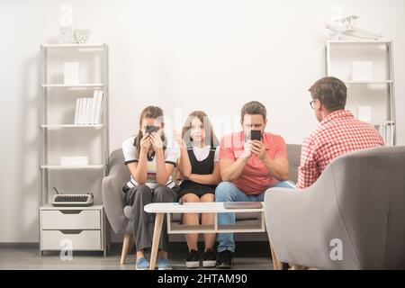 Telefon süchtig Mama Papa und Tochter. Lebensversicherung und Adoption. Eltern-Lehrer-Treffen. Stockfoto