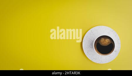 Draufsicht auf Kaffee in Becher auf gelbem Hintergrund mit Schaumstoff, der ein Lächeln bildet. Negativer Platz für Kopie. 3D Rendern. Stockfoto