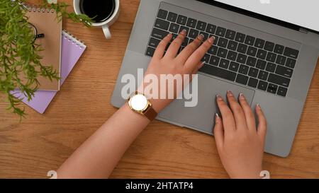 In der Kopfaufnahme tippt eine Frau oder eine Geschäftsfrau auf der Notebook-Tastatur und arbeitet ihr Online-Projekt auf einem Laptop-Computer. Stockfoto