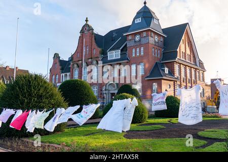 Wunderschöne Aussicht auf weiße Kleider, die mit schriftlichen Botschaften unter dem Rathaus Papenburg hängen Stockfoto