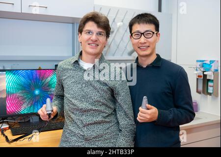 PRODUKTION - 03. Februar 2022, Baden-Württemberg, Tübingen: Georg Martius (l), Forschungsgruppenleiter am Max-Planck-Institut, und sein Doktorand Huanbo Sun halten einen Roboterdaumen, den sie gemeinsam am Institut entwickelt haben. Foto: Silas Stein/dpa Stockfoto