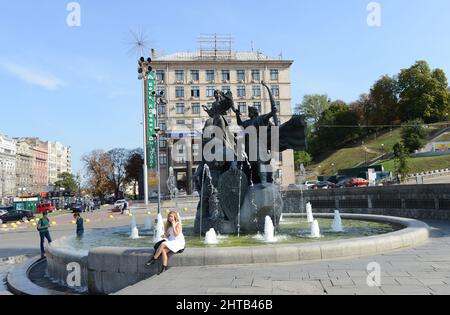 Denkmal für Gründer von Kiew - Kyi, Shchek, Khoryv und Lybid auf dem Unabhängigkeitsplatz, Kiew, Ukraine. Hotel Ukrayina auf Hintergrund Stockfoto