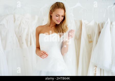 Shes gehen, um eine schöne Braut zu machen. Eine junge Braut, die ihr Hochzeitskleid anprobiert - Copyspace. Stockfoto