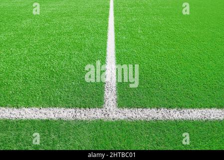 Ein Teil des Fußballfeldes aus der Nähe, künstliches grünes Gras mit weißen Randlinien, Astroturf im Stadion für Sportenspiele Stockfoto