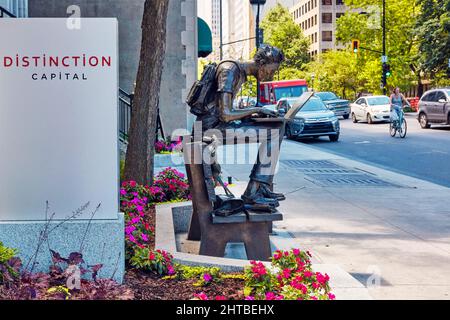 Juni, 2018 - Montreal, Kanada: Statue der McGill-Universität, die auf einer Bank sitzt und einen Laptop-pc in der Sherbrooke Street in Montreal, Quebec, verwendet Stockfoto