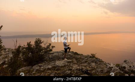 Luftaufnahme eines Mannes, der eine Drohne auf dem Berg Biokovo in Kroatien kontrolliert Stockfoto