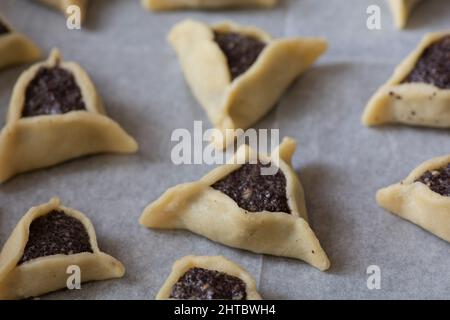 Vorgebackene 'Haman Pockets', auch bekannt als Hamantashen, ein aschkenasisch-jüdisches dreieckiges gefülltes Plätzchen, das normalerweise mit dem jüdischen Feiertag in Verbindung gebracht wird Stockfoto