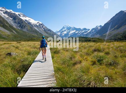 Kaukasische Frau, die im Hooker Valley zum Aoraki Mount Cook in Neuseeland wandert Stockfoto