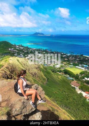 Weibchen sitzt auf einem Felsen und genießt eine wunderschöne Aussicht in Oahu, Hawaii Stockfoto