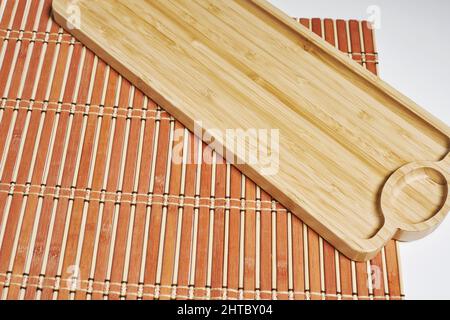 Nahaufnahme einer Bambusususususususrollmatte und einem auf weißem Hintergrund isolierten Holztablett Stockfoto