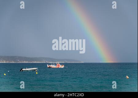 Regenbogen- und Fischerboote auf See. Das Foto wurde an einem bewölkten Tag aufgenommen Stockfoto