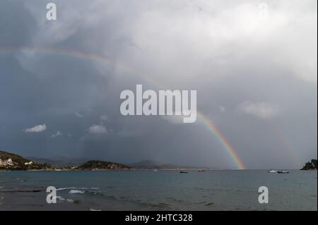 Regenbogen- und Fischerboote auf See. Das Foto wurde an einem bewölkten Tag aufgenommen Stockfoto