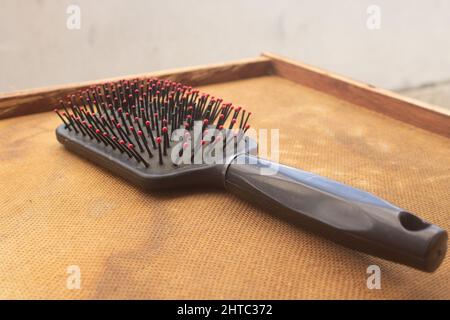 Nahaufnahme eines Kamms auf einer Holzschublade Stockfoto