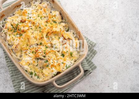 Weißer Fischauflauf mit Blumenkohl, Kartoffeln mit Käse, Sauerrahm und Zwiebeln Stockfoto