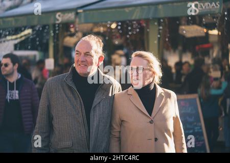 Das Seniorenpaar läuft an einem sonnigen Tag gerne durch den Markt in München Stockfoto