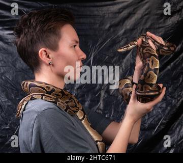 Foto einer Frau, die in die Augen der Schlangen schaut Stockfoto