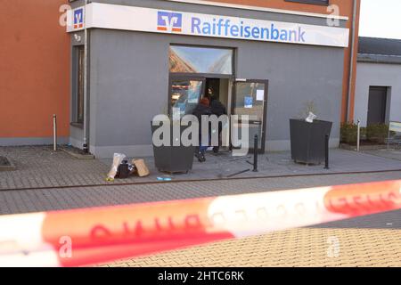 Grafschaft Bellen, Deutschland. 28.. Februar 2022. Polizeibeamte sichern sich nach der Detonation eines Geldautomaten in Grafschaft-Bellen Beweise. Das Bankgebäude wurde durch die Detonation schwer beschädigt. Quelle: Thomas Frey/dpa/Alamy Live News Stockfoto